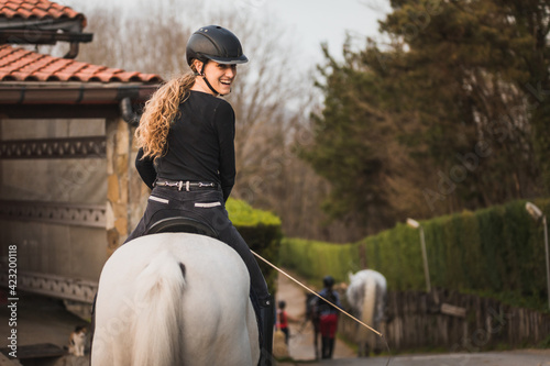 Young caucasian woman riding a horse in a horse centre