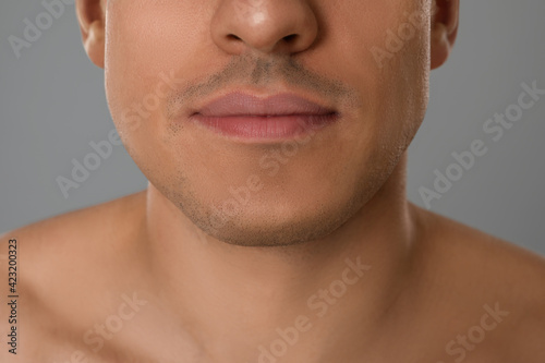 Man after shaving on grey background, closeup
