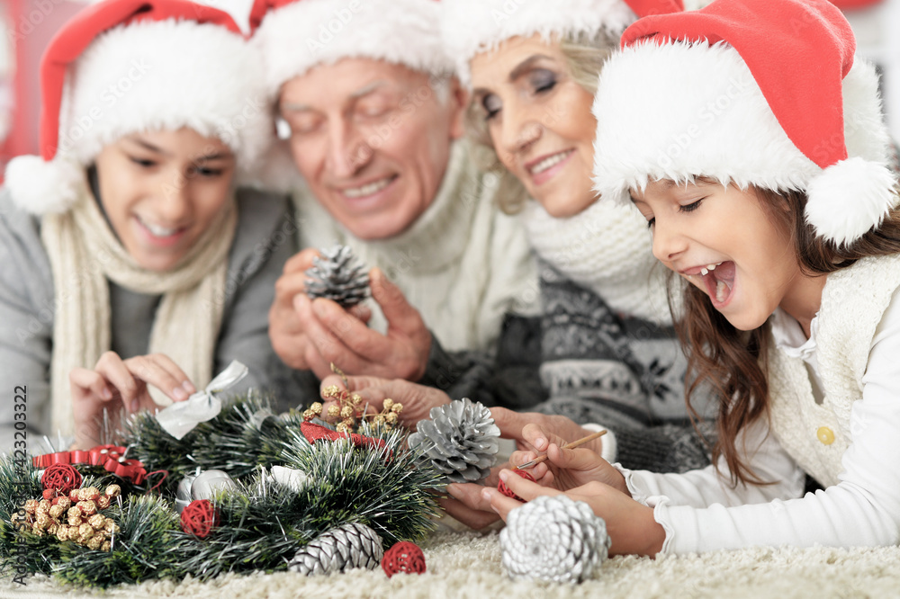 Portrait of happy family in Santa hats  on the floor