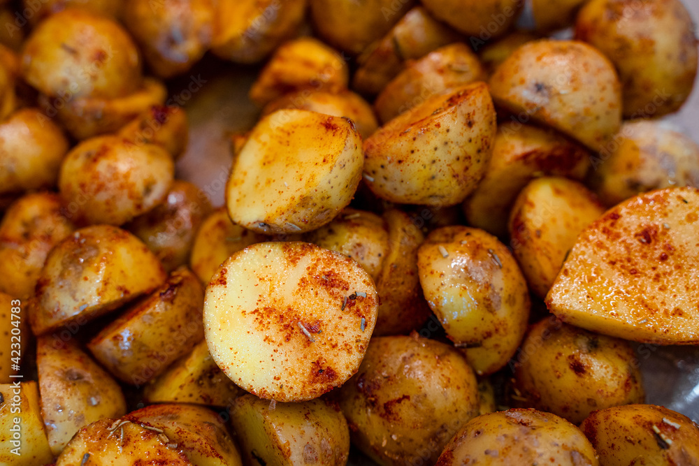 New potatoes cut in half and marinated with rosemary and paprika. Beautiful food background New potatoes cut in half and marinated with rosemary and paprika. Beautiful food background