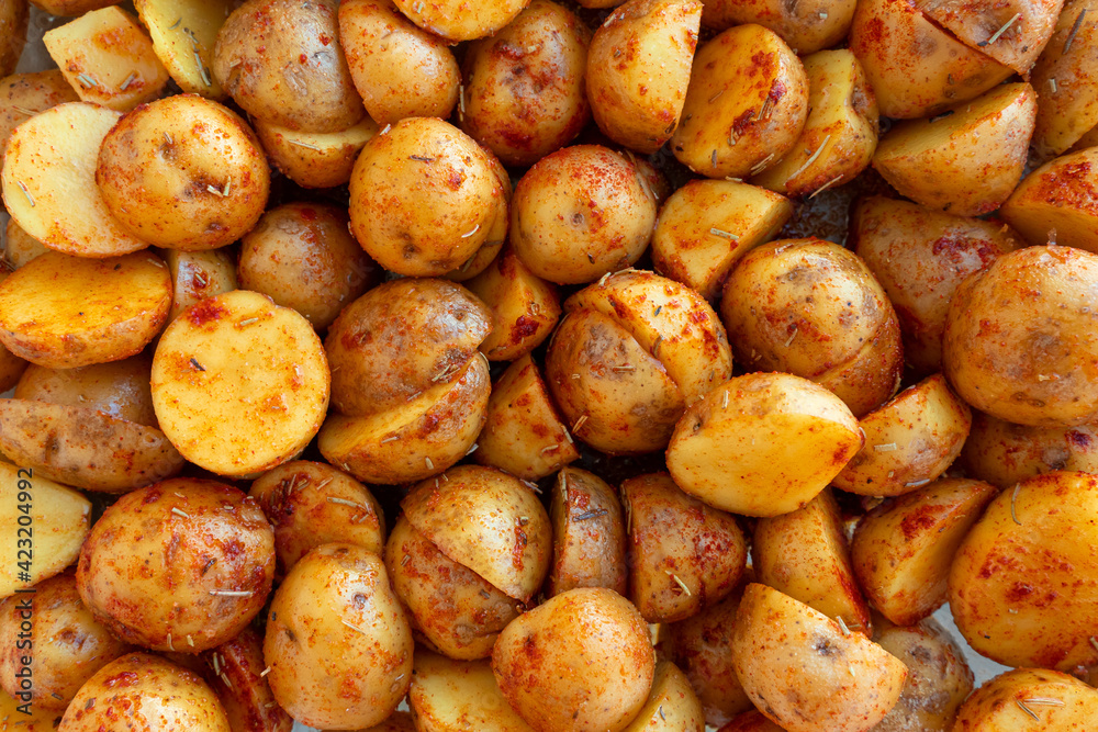 New potatoes cut in half and marinated with rosemary and paprika. Beautiful food background New potatoes cut in half and marinated with rosemary and paprika. Beautiful food background