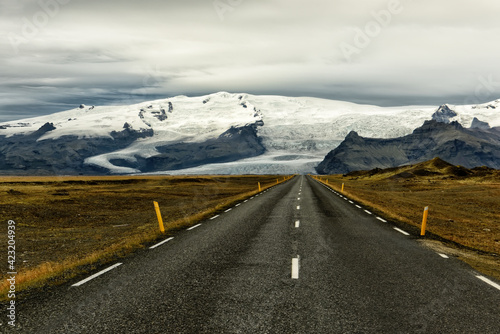 a deserted asphalt road running away into the hills. Iceland. The spirit of travel and adventure. 