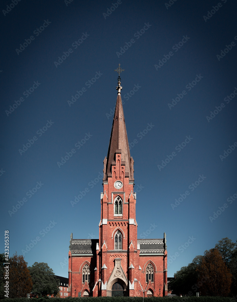 The facade and steeple of the brick church Allhelgonakyrkan in Lund Sweden