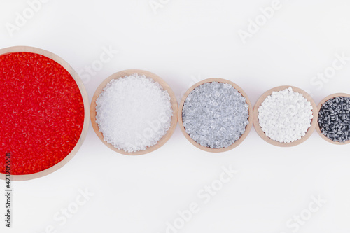 Polymer products of different colors in containers on a white background.Polymers and polystyrene.Chemical industry.Inorganic and organic,amorphous and crystalline substances,high molecular compound