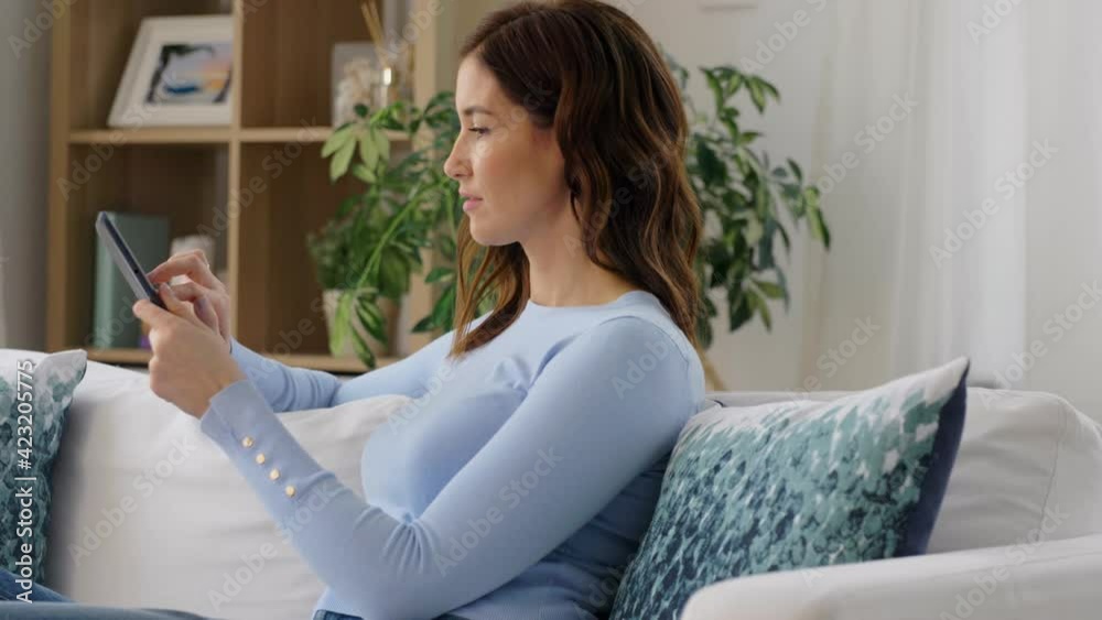 people, technology and leisure concept - happy young woman with tablet pc computer sitting in chair at home people, technology and leisure concept - happy young woman with tablet pc computer sitting in chair at home