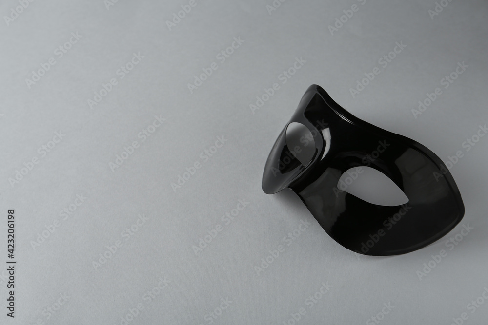 Black theatre mask on grey background, space for text Black theatre mask on grey background, space for text