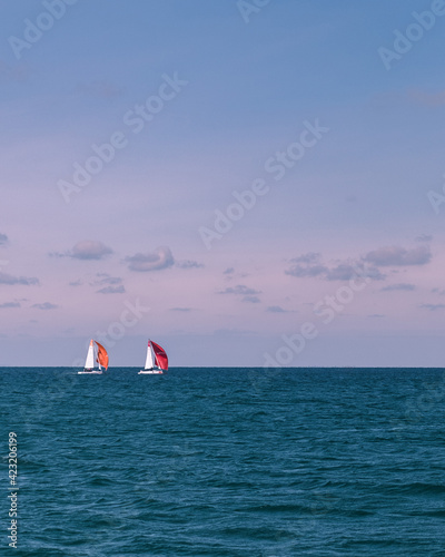 Photography of a summer sea and bright yachts. Blue water and clear sky. Sailboat in the ocean. Tropical climate.