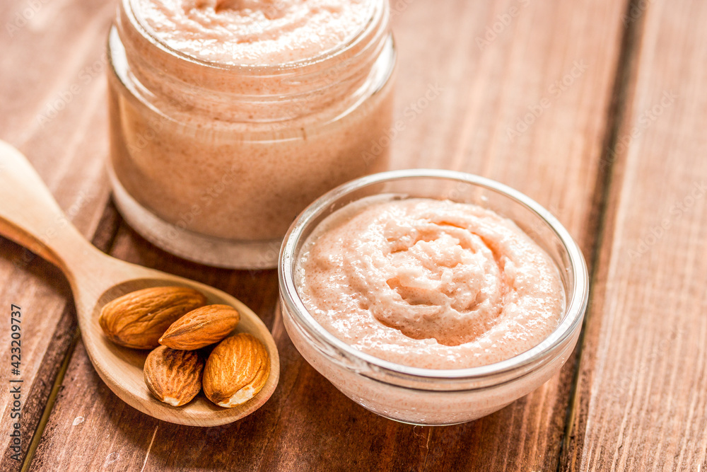 body scrub with almonds for body care on wooden table background body scrub with almonds for body care on wooden table background