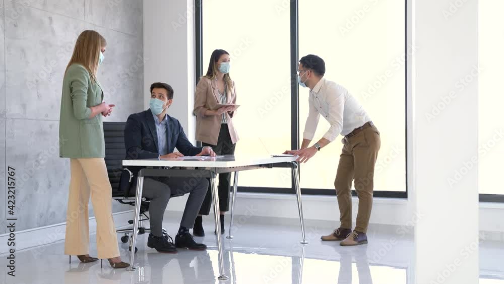 Business people wearing masks and social distancing in office Business people wearing masks and social distancing in office