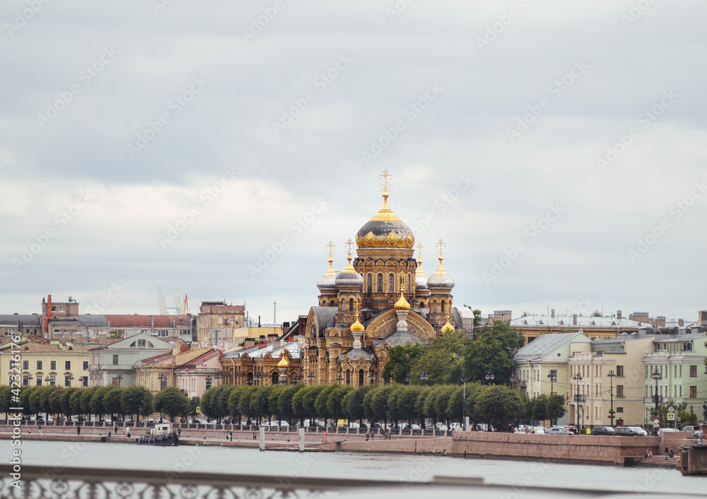 Saint-Petersburg, Russia, 31 August 2020: Church of the Assumption of the Blessed Virgin Mary on Vasilievsky Island. In the foreground is the Neva River. View of the Lieutenant Schmidt embankment.