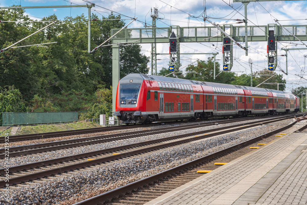 Ein Personenzug fährt durch einen Bahnhof  ohne Halt