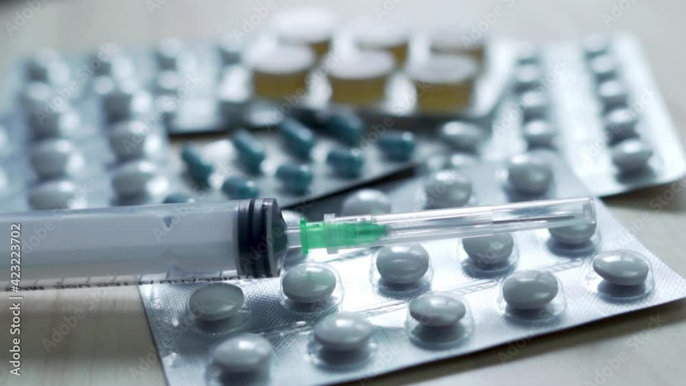 Macro Syringe and Tablets, Rotate. Medicines, Medicines, Vitamins, Antibiotics, Painkillers and a Syringe with a Needle. Medicine and Pharmaceuticals. Macro Syringe and Tablets, Rotate. Medicines, Medicines, Vitamins, Antibiotics, Painkillers and a Syringe with a Needle. Medicine and Pharmaceuticals.