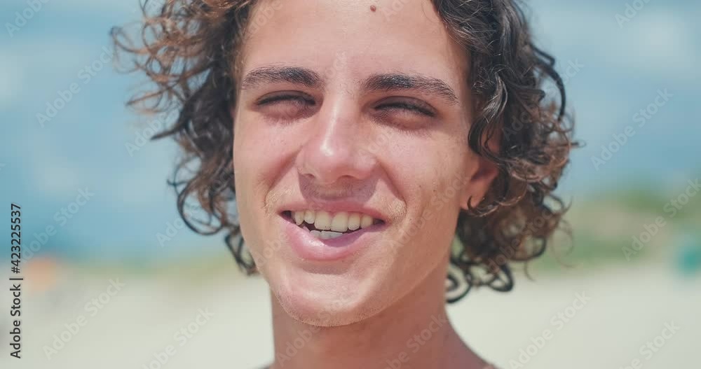 Young man's portrait. Close up portrait of the young Brazilian surfer on the beach. Hand held camera Young man's portrait. Close up portrait of the young Brazilian surfer on the beach. Hand held camera