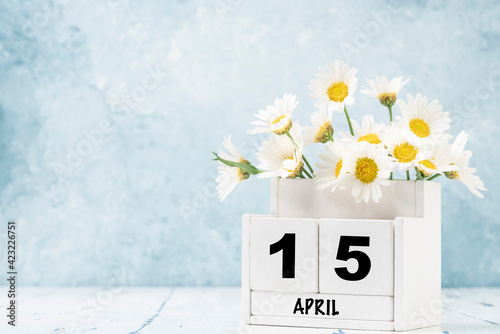Tableau sur toile cube calendar for april decorated with daisy flowers over blue with copy space