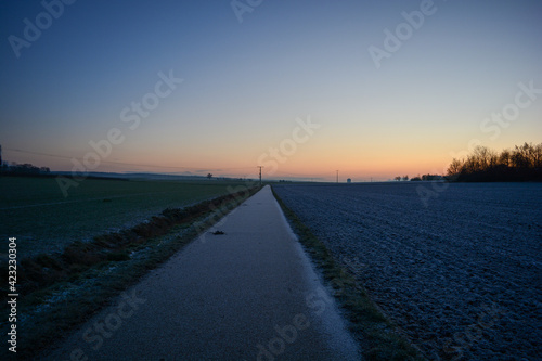 Frostiger Morgen in Schweinfurt mit Sonnenaufgang über den Feldern bei Niederwerrn in Franken mit wolkenloser Himmel im Winter, Franken, Bayern, Deuschland 