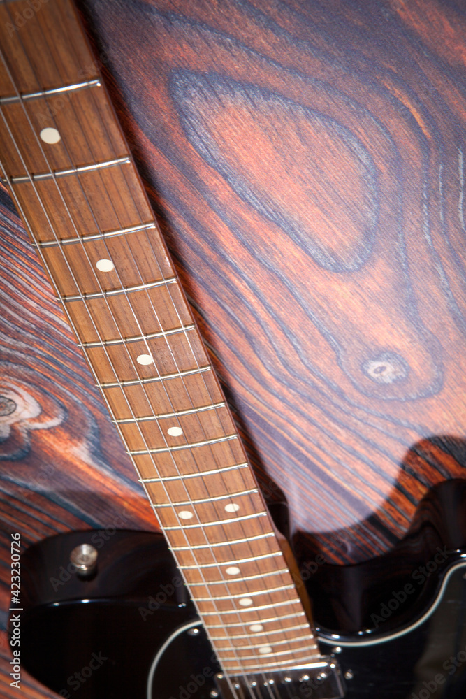 Obraz premium Black electric guitar on old wooden background. Close up
