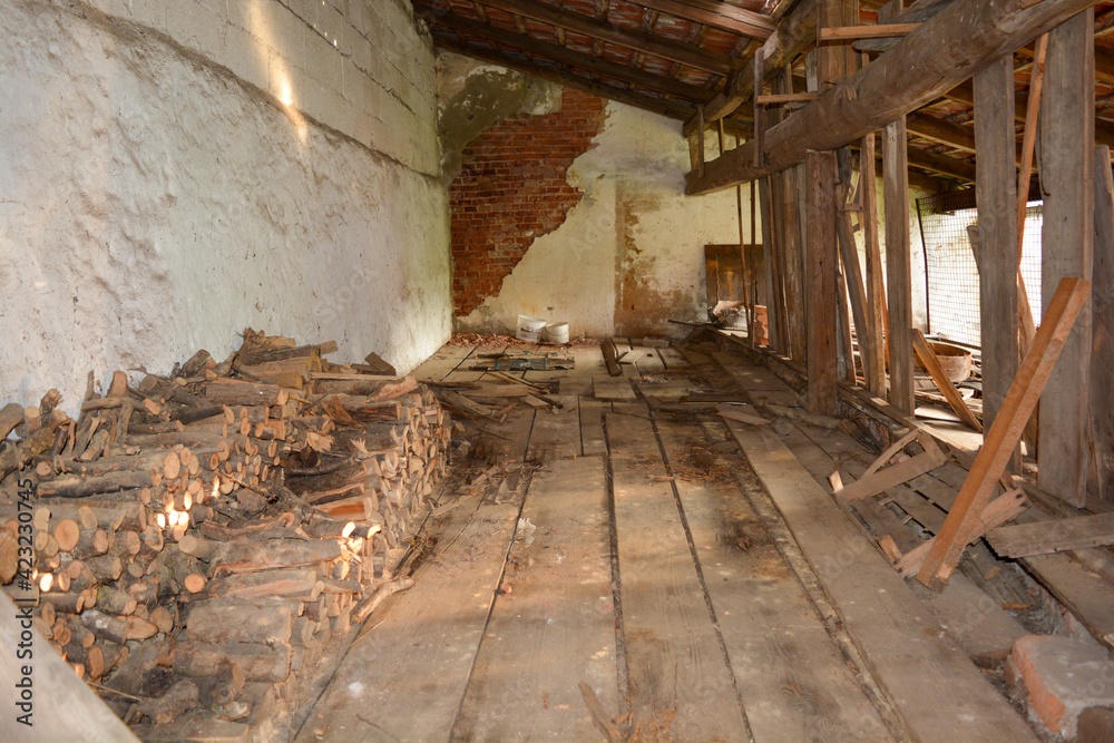 Alte Scheune von innen mit Holzboden und Holzstapeln Alte Scheune von innen mit Holzboden und Holzstapeln
