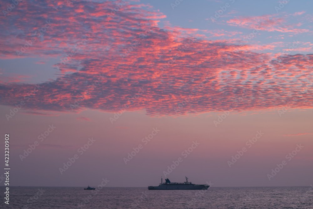 Φωτογραφία A ship traveling in the horizon, glorious colorful sunset skies, calm low tide ocean shore, view from the famous Galle fort