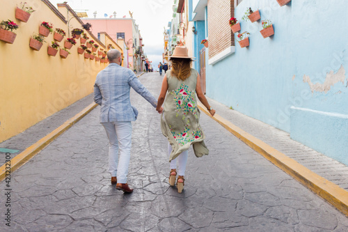 Pareja vacacionando en mexico con pueblo magico de fondo