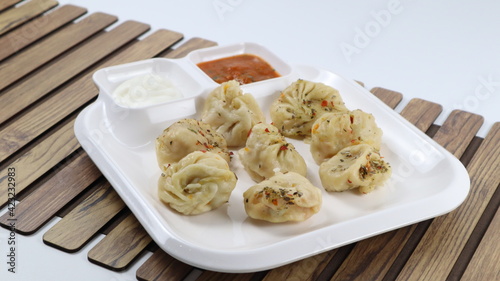 Veg steam momos. Momos stuffed with vegetables and then cooked and served with sauce, The name momo spread to Tibet, India and Nepal and usually now refers to filled buns or dumplings. 