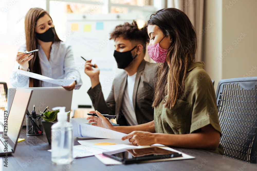 Business team wearing protective masks while meeting in the office during the COVID-19 epidemic Business team wearing protective masks while meeting in the office during the COVID-19 epidemic