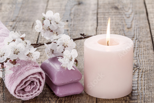 Soap with towel for bathroom procedures and burning candle with flowers