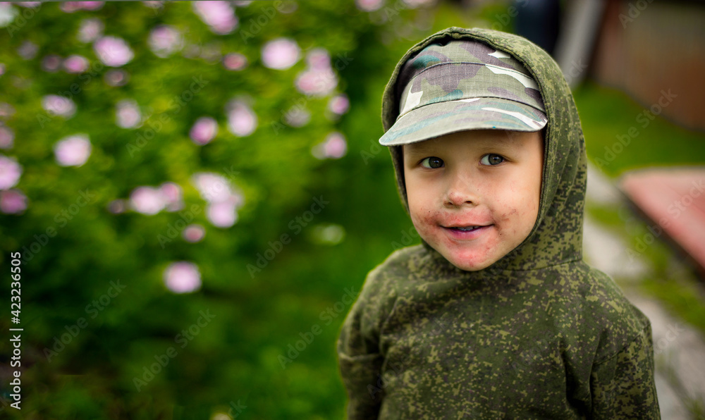 Happy boy, cheeks in the traces of blueberries playing outdoors, banner, place for text, selective focus Happy boy, cheeks in the traces of blueberries playing outdoors, banner, place for text, selective focus