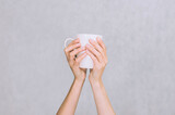 White mug for coffee, tea in the hands of a girl. On a white background.