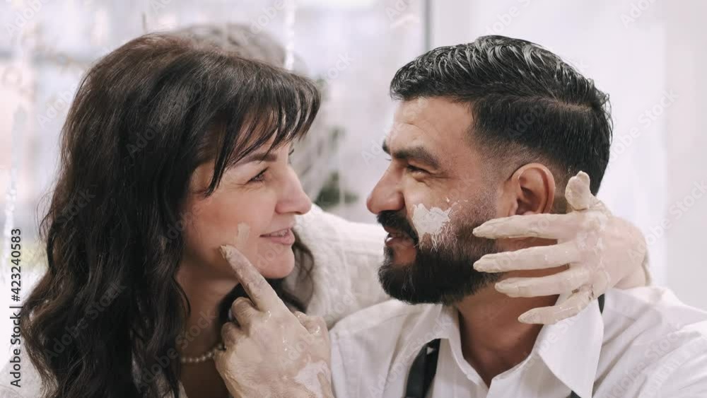 Happy married middle aged couple having a date in pottery workshop