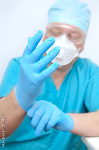 The doctor put on sterile gloves. Preparing for surgery