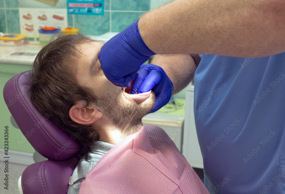 Foto de Team of dental surgeons performs surgery on teeth. in a modern
