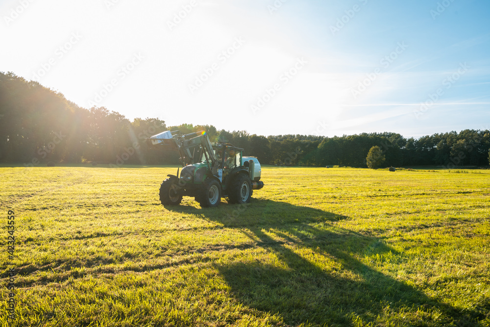 Fototapeta premium Traktor foliert Strohballen ein