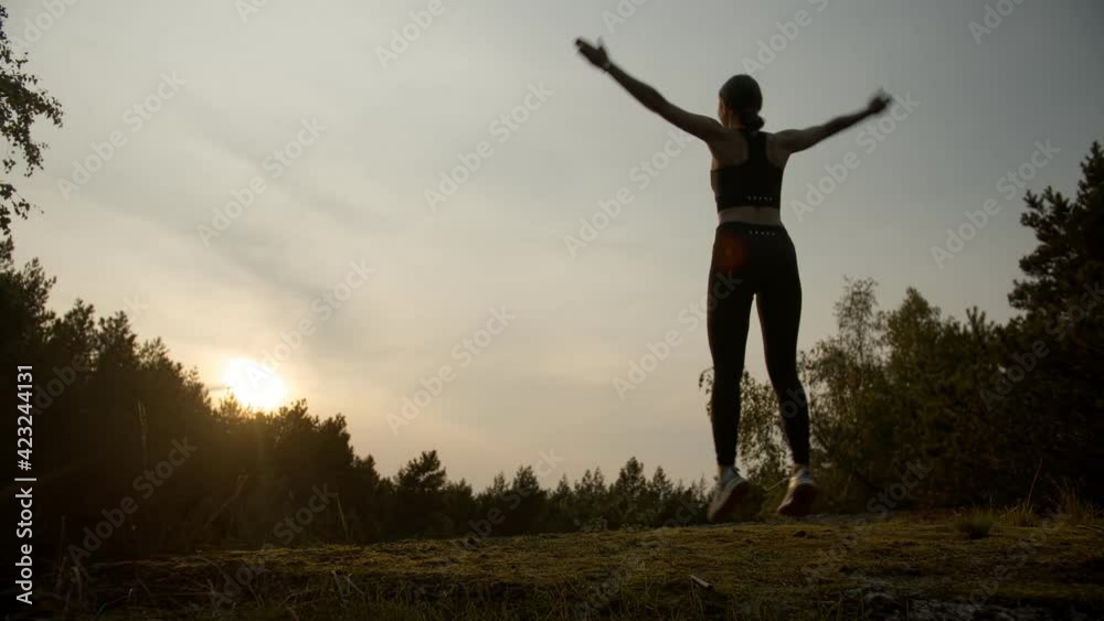 Young sportswoman exercising outdoors on sunset background Young sportswoman exercising outdoors on sunset background