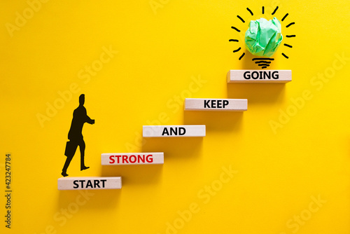 Start strong and keep going symbol. Concept words 'Start strong and keep going' on wooden blocks on a beautiful yellow background. Businessman icon. Business, motivational and start strong concept.