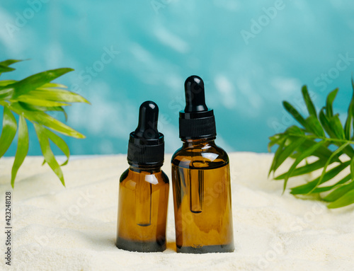 Photography Brown glass bottles on a summer beach background, summer skin care concept