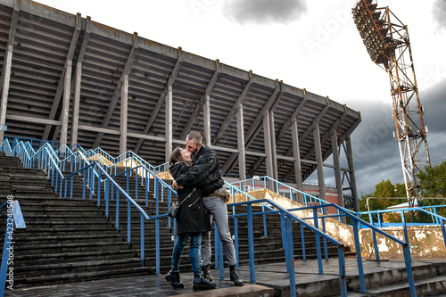 Old school football fan in love kisses his beloved at the stadium after the match