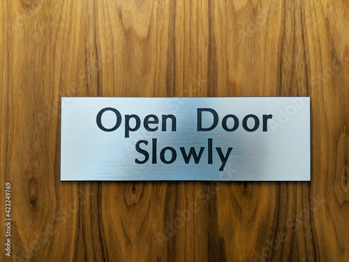 Canvas Print Open door slowly sign on a wood door.