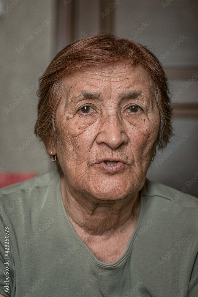 Close-up portrait of an elderly wrinkled woman.