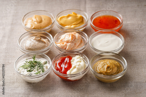Assortment of sauces. A set of different sauces on the table is covered with a light linen cloth.