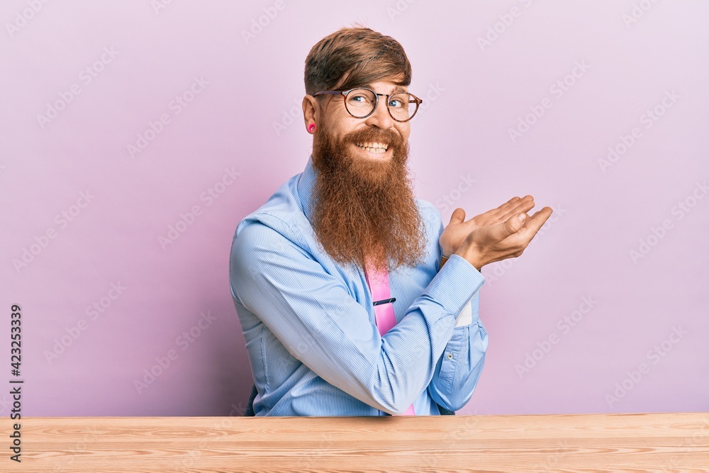 Young irish redhead man wearing business shirt and tie sitting on the table pointing aside with hands open palms showing copy space, presenting advertisement smiling excited happy Young irish redhead man wearing business shirt and tie sitting on the table pointing aside with hands open palms showing copy space, presenting advertisement smiling excited happy