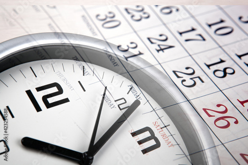 large white clock face with calendar sheets