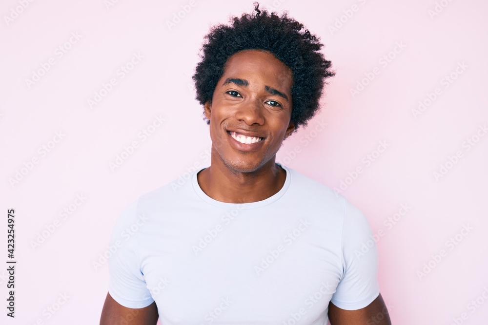 Handsome african american man with afro hair wearing casual clothes looking positive and happy standing and smiling with a confident smile showing teeth