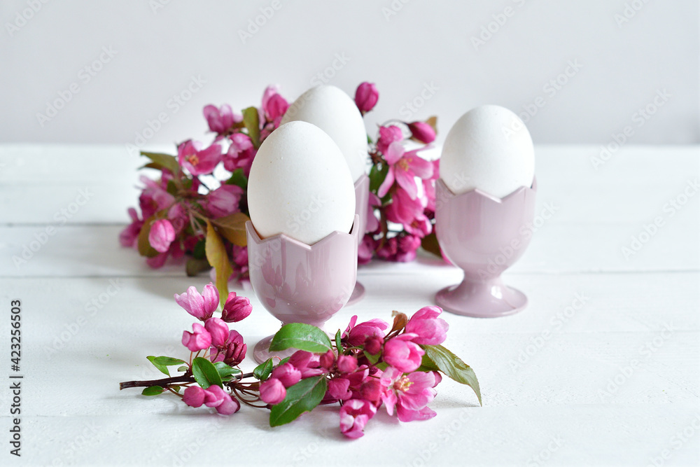 Happy Easter holiday concept with eggs and fresh flowers on white table background. Greeting card. Easter background. Happy Easter holiday concept with eggs and fresh flowers on white table background. Greeting card. Easter background.