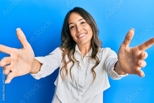 Young brunette woman wearing casual clothes looking at the camera smiling with open arms for hug. cheerful expression embracing happiness.