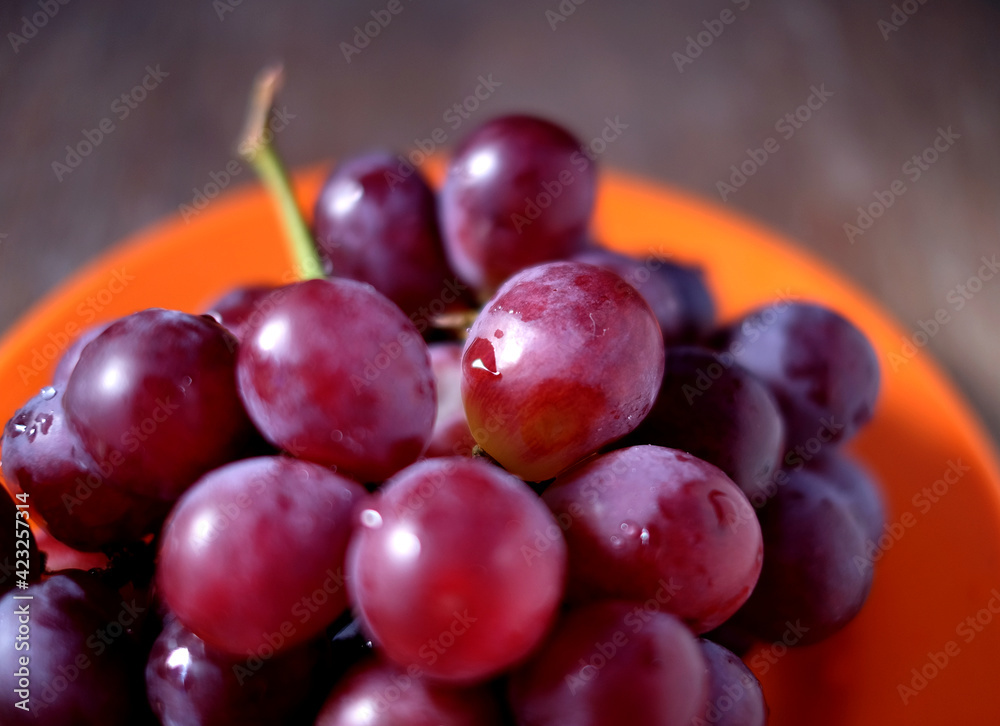 Tasty red grapes on plate, selective perspective view, partial detail. Tasty red grapes on plate, selective perspective view, partial detail.