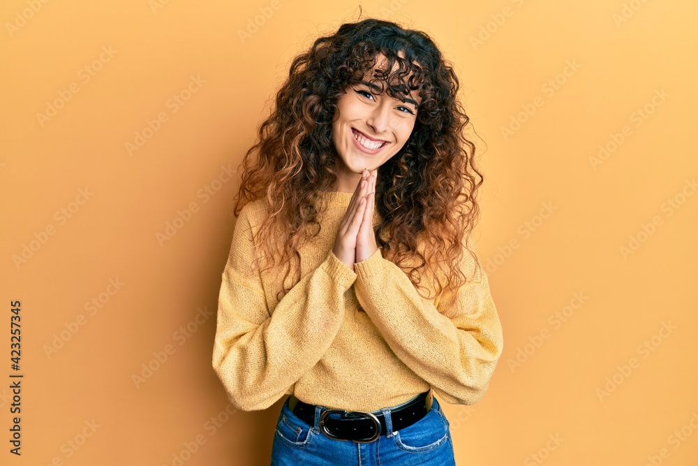 Young hispanic girl wearing casual clothes praying with hands together asking for forgiveness smiling confident. Young hispanic girl wearing casual clothes praying with hands together asking for forgiveness smiling confident.