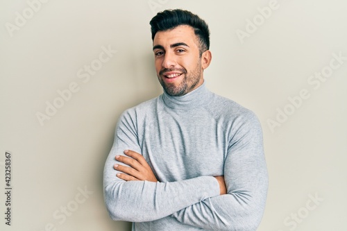 Young hispanic man wearing casual clothes happy face smiling with crossed arms looking at the camera. positive person.