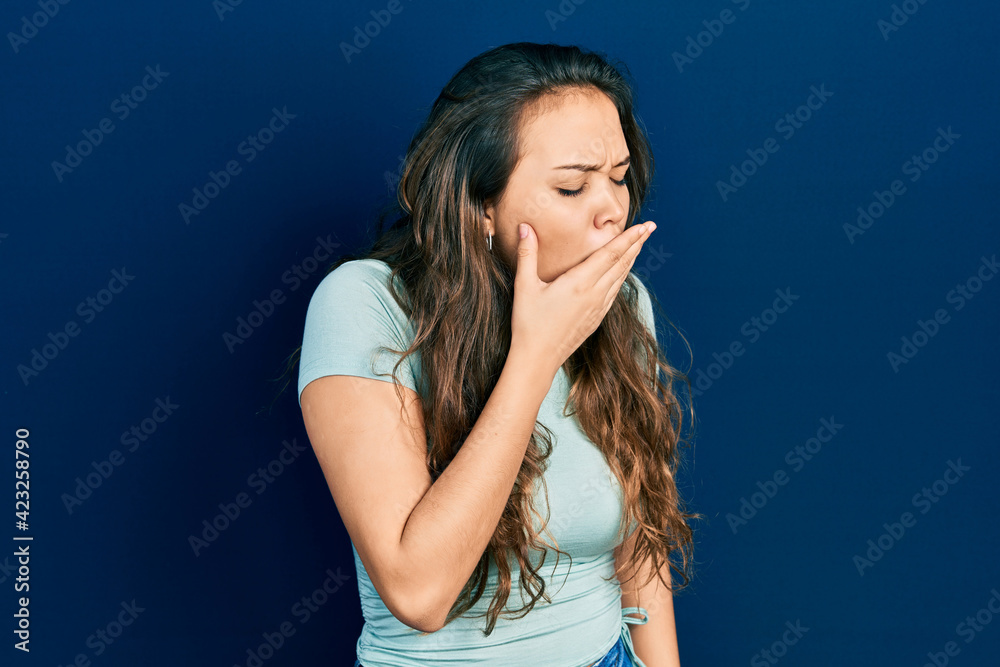 Young hispanic girl wearing casual clothes bored yawning tired covering mouth with hand. restless and sleepiness. Young hispanic girl wearing casual clothes bored yawning tired covering mouth with hand. restless and sleepiness.