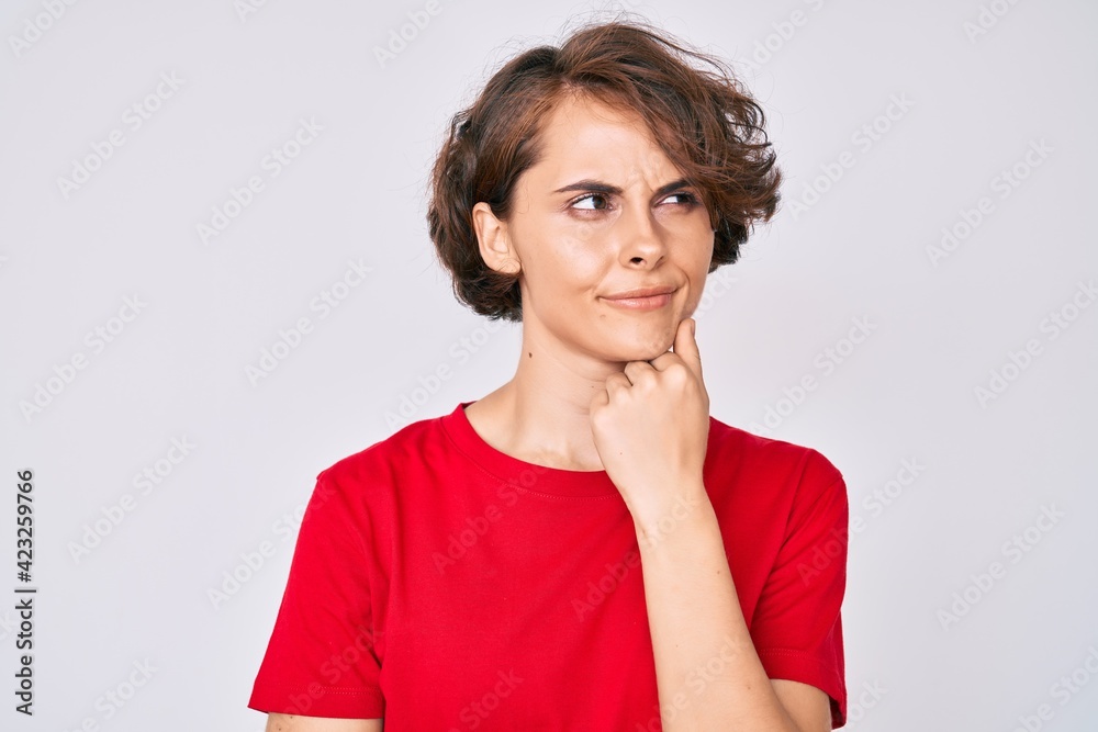 Young hispanic woman wearing casual clothes thinking concentrated about doubt with finger on chin and looking up wondering