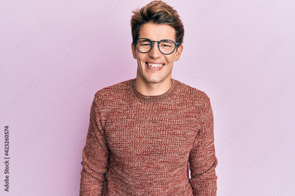 Handsome caucasian man wearing casual sweater and glasses with a happy and cool smile on face. lucky person. Handsome caucasian man wearing casual sweater and glasses with a happy and cool smile on face. lucky person.